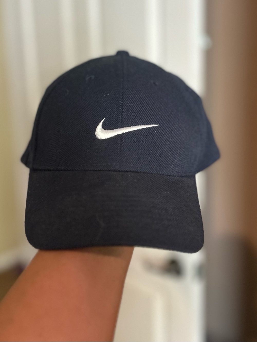 Black Nike baseball cap featuring a centered white embroidered Swoosh